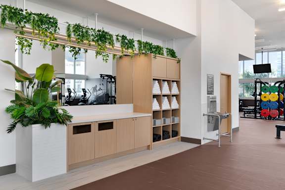 A modern office space with a green plant hanging from the ceiling. at Olympic + Hill Apartments, Apartments, Los Angeles, CA