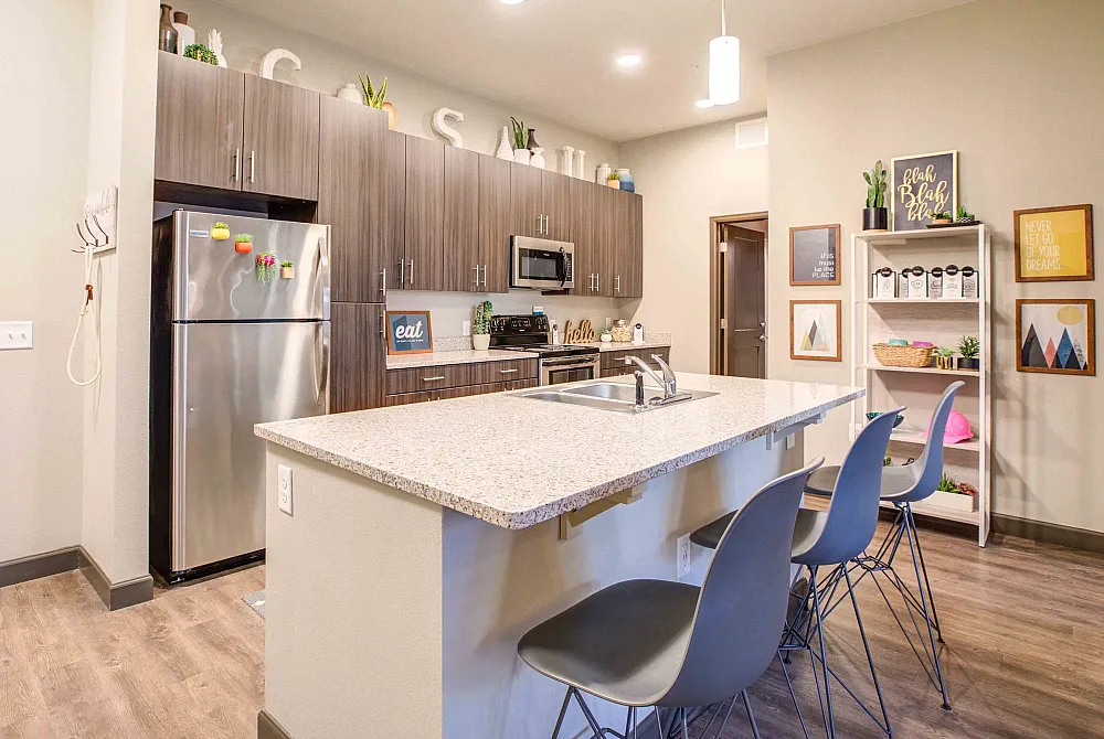 Model apartment kitchen with granite countertop and stainless steel appliances