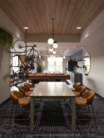 Modern apartment space featuring a sleek dining table with cozy chairs, a stylish hanging bicycle, and a captivating pool table in a well-lit, contemporary setting.