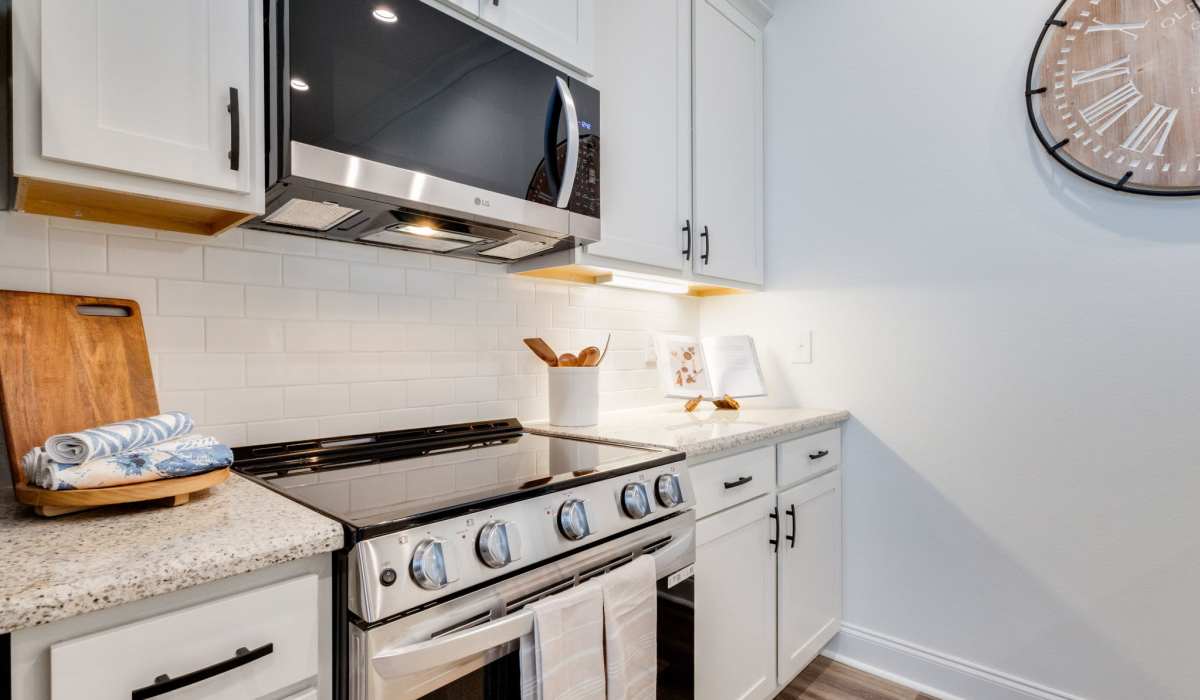 Modern kitchen with granite countertops, stainless steel appliances, and wood-style flooring at Lakewood Villas in Bossier City, Louisiana