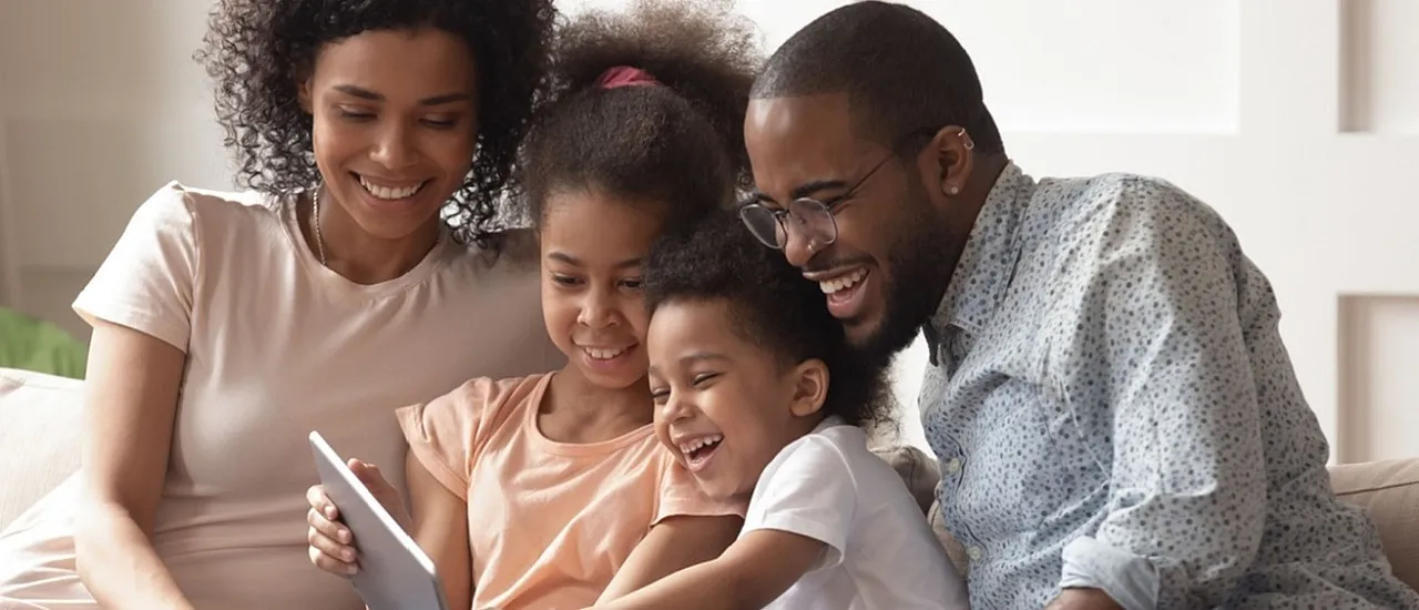 Happy family enjoying quality time together on a cozy sofa, creating joyful moments.