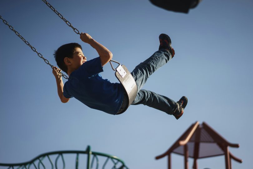 Child playing on playground slide at L'Abri Apartments