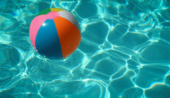 A beach ball floating in a pool of water.