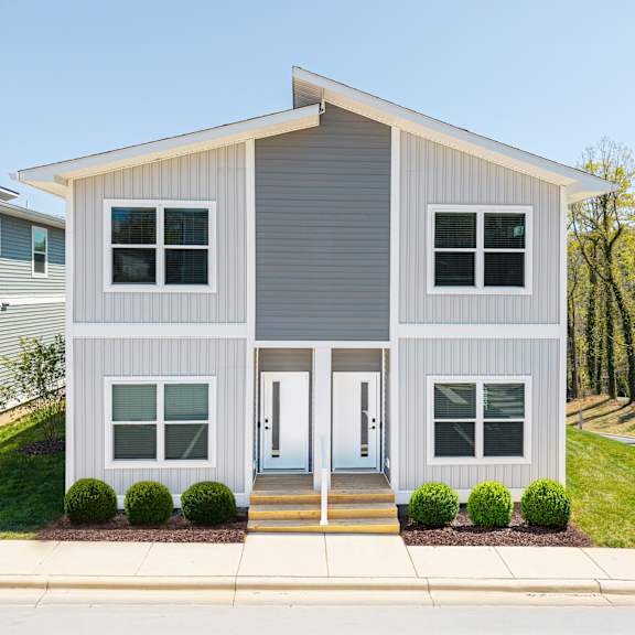 A two-story house with a grey exterior and white trim.