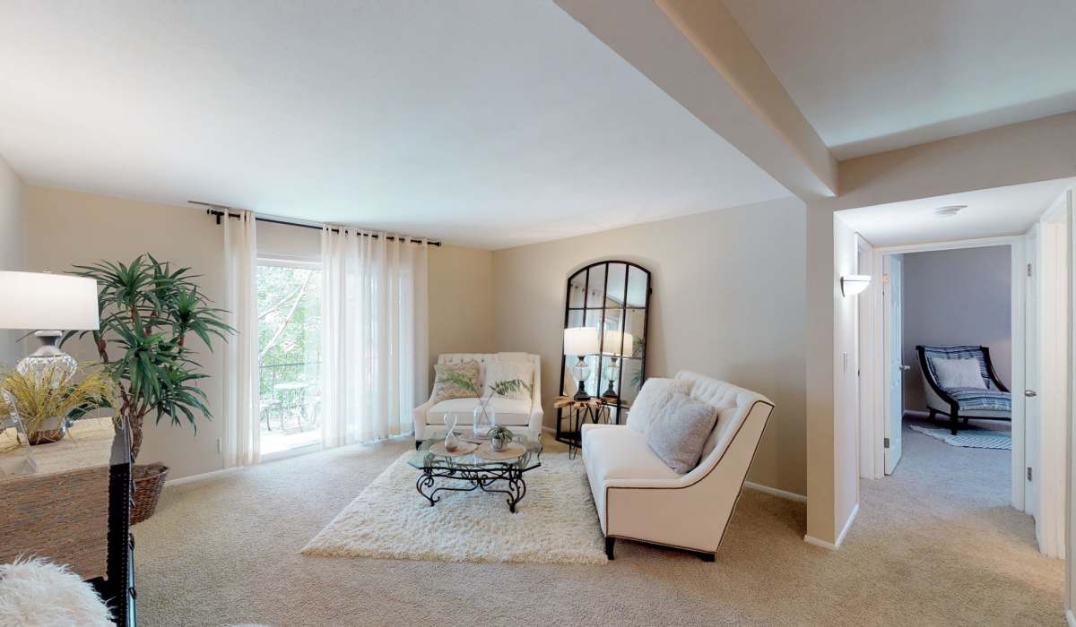 Living room with carpet flooring and access to patio at Beau Jardin Apartments in St. Louis, Missouri