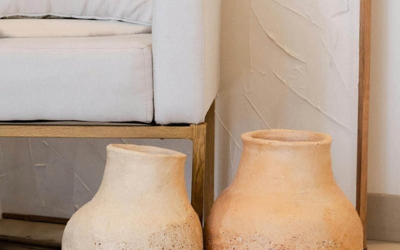 a group of clay vases and a white chair