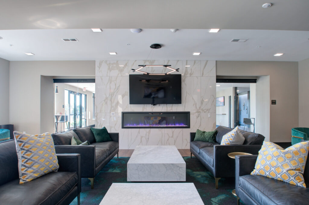 Lounge at luxury Cherry Hill townhomes featuring marble fireplace and designer furnishings