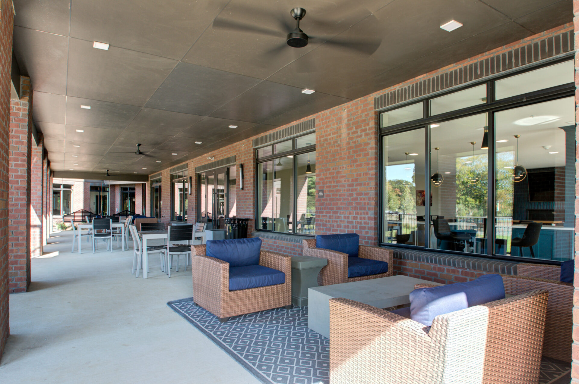 Outdoor patio with seating and ceiling fans.