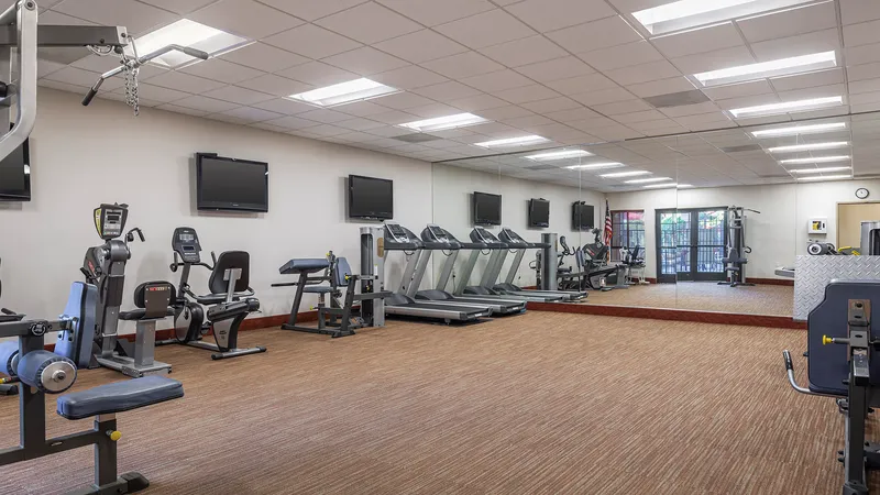 Fitness center offers stationary bike equipment, hand weights and a large mirror