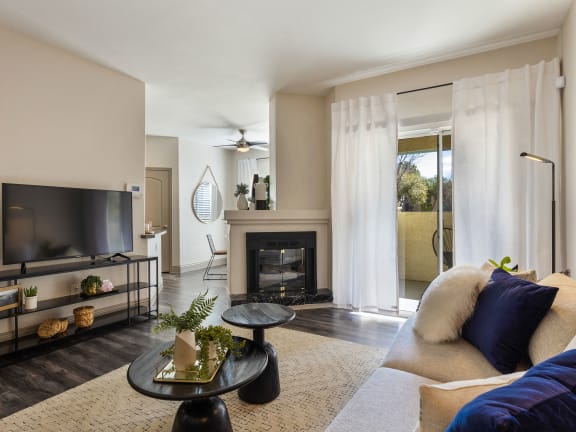 a living room with a couch and a tv and a fireplace at Mirasol Apartments, Las Vegas