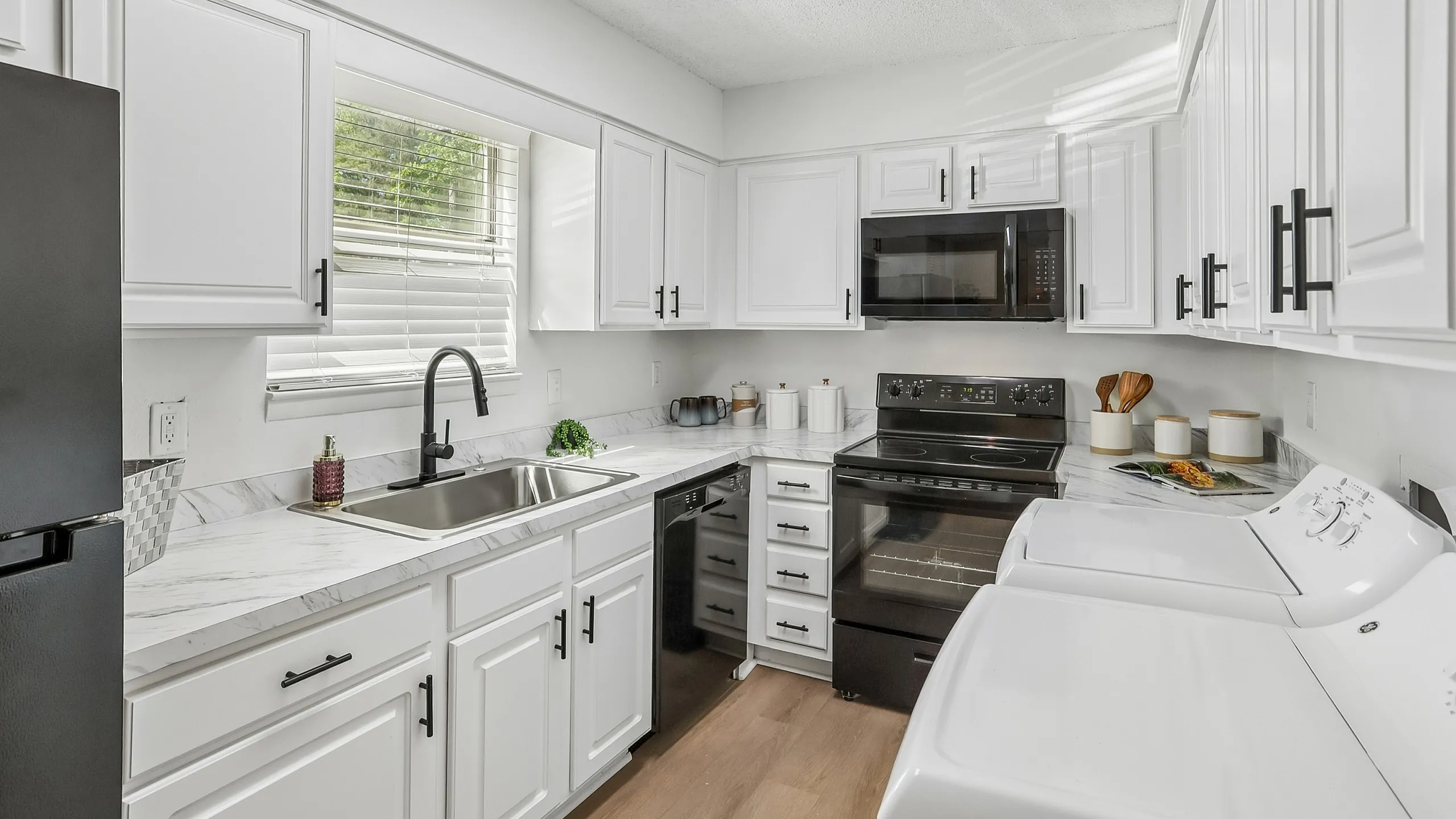 Bright kitchen with sleek white cabinetry, modern appliances, and elegant countertops.