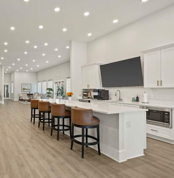 A modern kitchen with a bar area and a dining table.