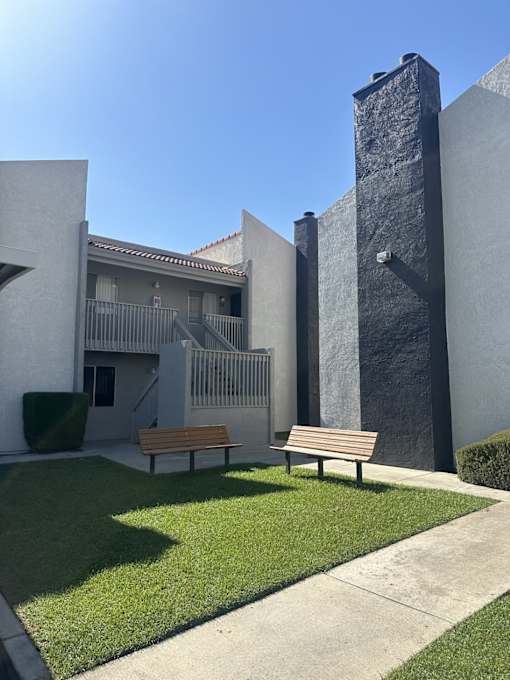 a courtyard with two benches in front of a building