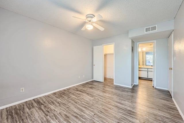 Bedroom with wood-look flooring, ceiling fan, and closet.