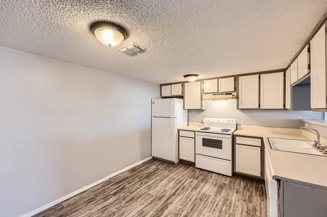 Kitchen with white appliances, cabinets, and countertops.