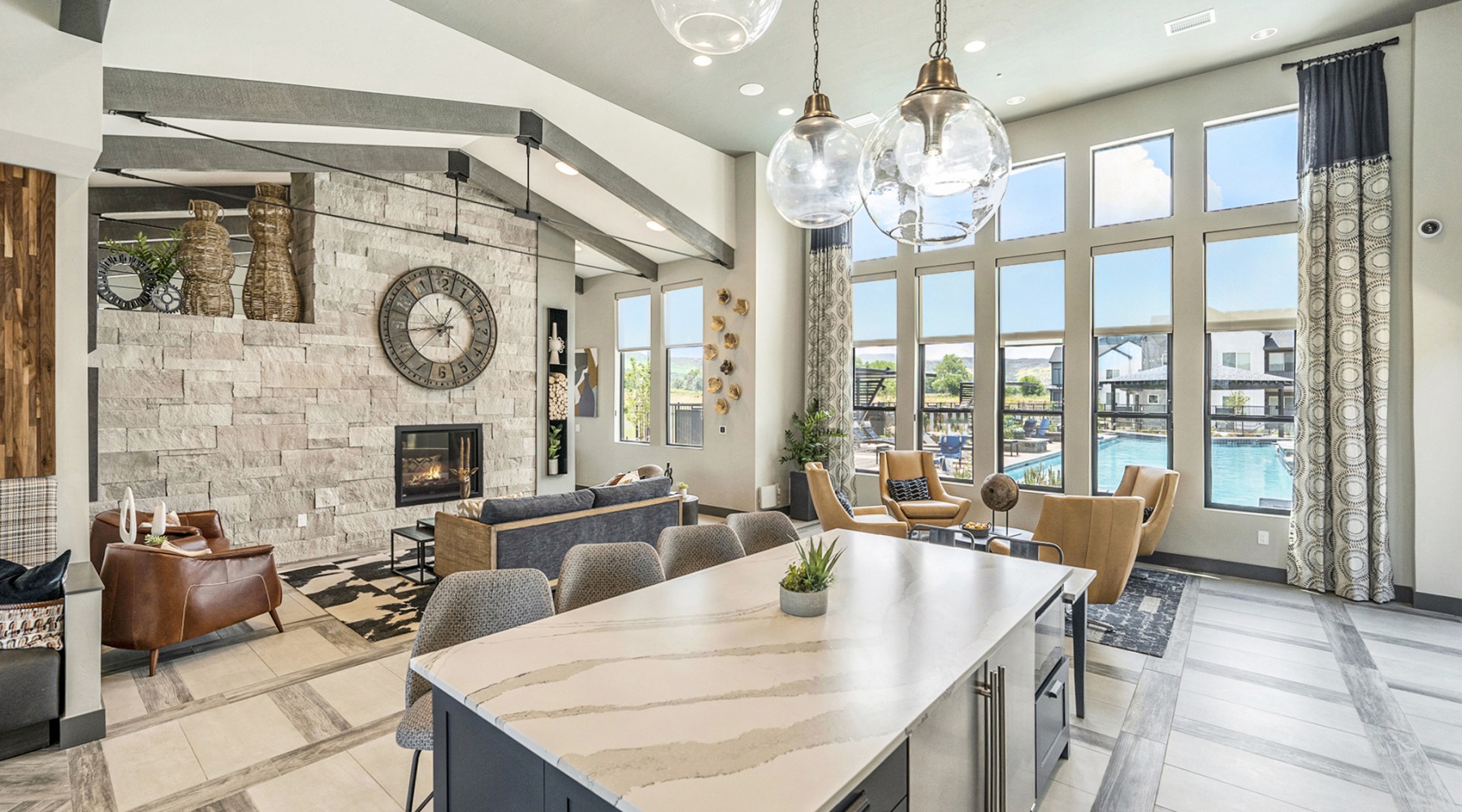 Clubroom with kitchen island, couches, and pool view