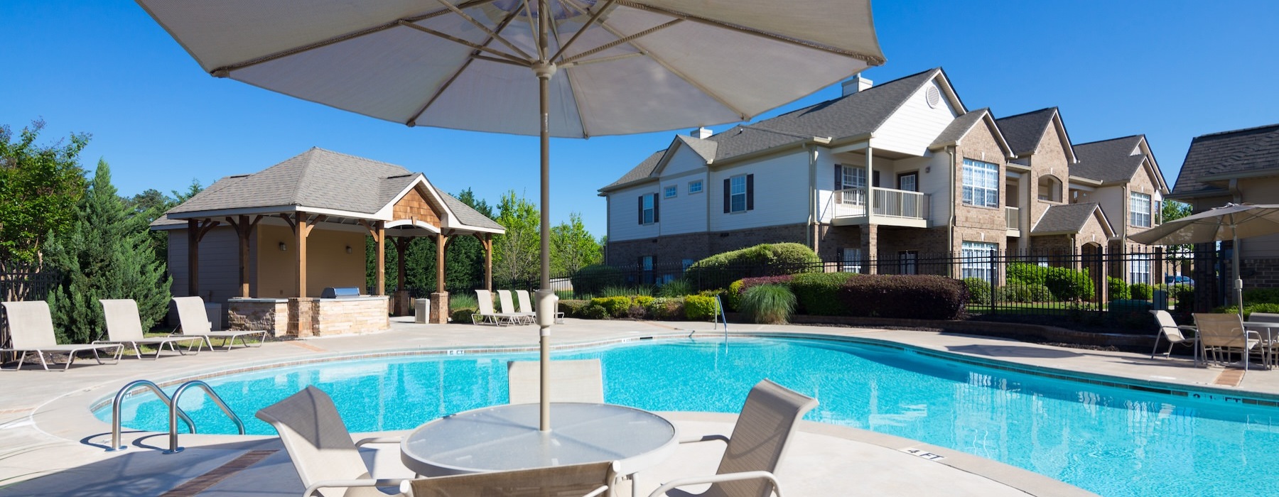 a pool with a lounge chair and umbrella by it