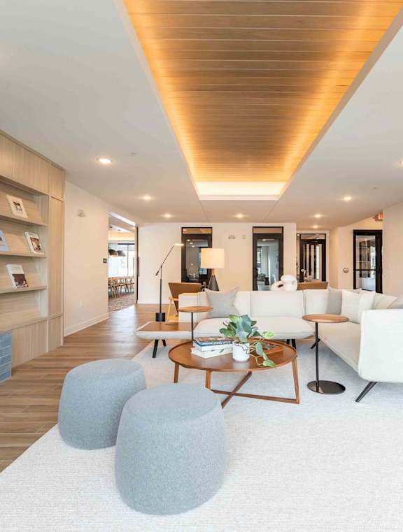 A modern living room with a fireplace and a white rug.