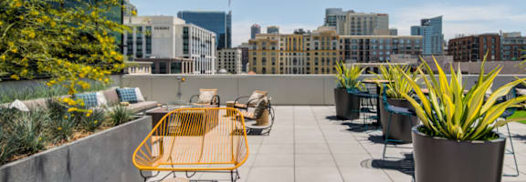 A yellow chair is on a patio with a view of the city.