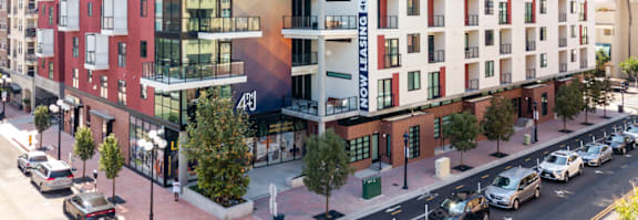 A street view of a building with cars parked on the side of the road.
