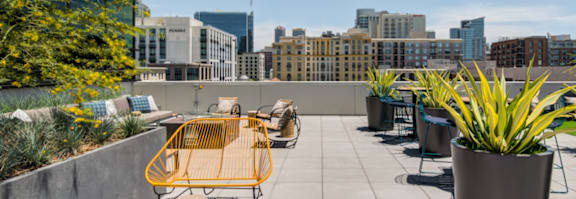 A yellow chair is on a patio with a view of the city.