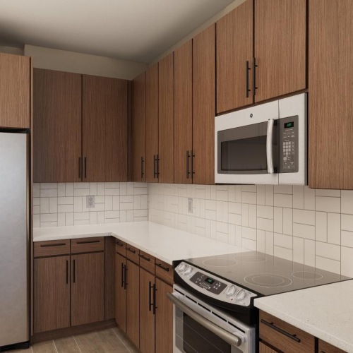 Model kitchen at Weller at the Preserve senior apartments in Asheville, featuring tiled backsplash and wood grain cabinets.