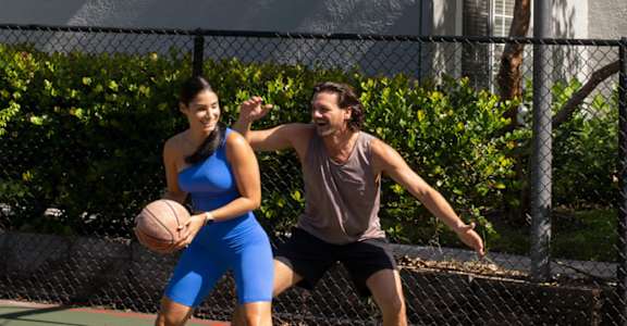a man and a woman playing basketball on a court