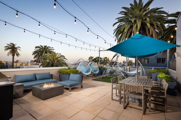 a patio with a firepit and chairs and tables