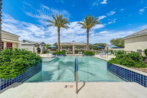 Swimming pool with blue tile and handrails at Vistoria On Camelback Apartments, Litchfield Park, AZ 85340