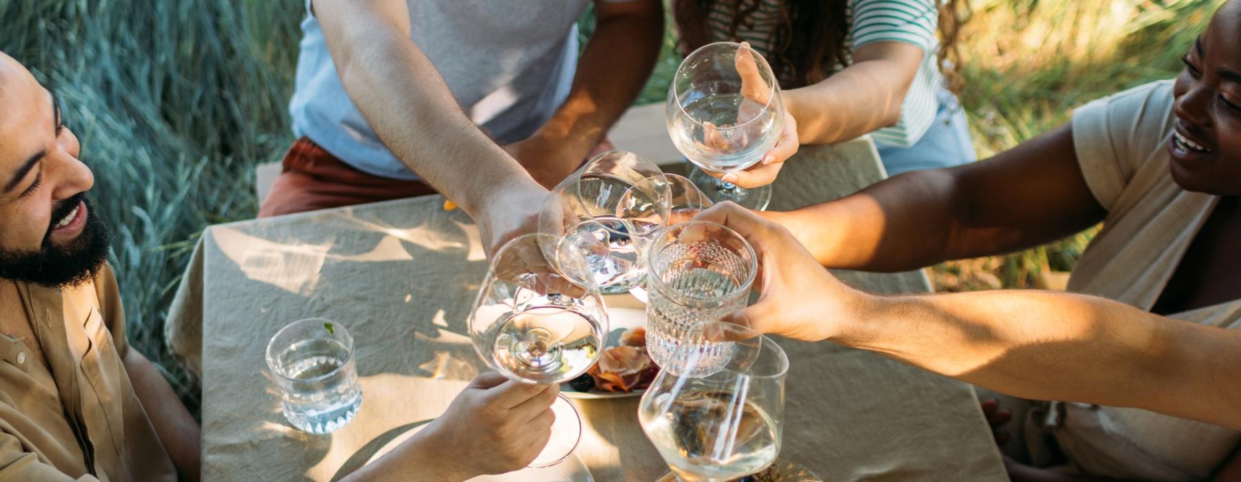 a group of people sitting around a table with food and drinks
