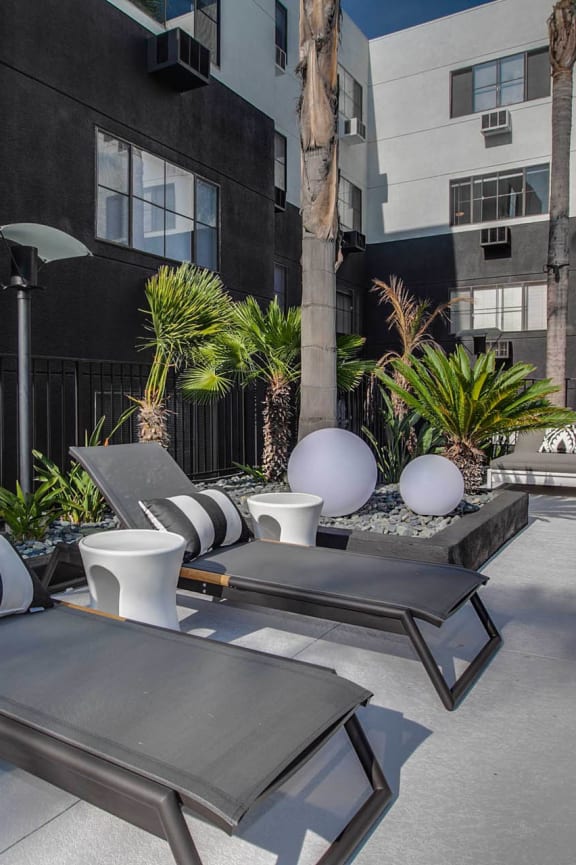 a patio with lounge chairs next to a pool at Duet on Wilcox, Los Angeles