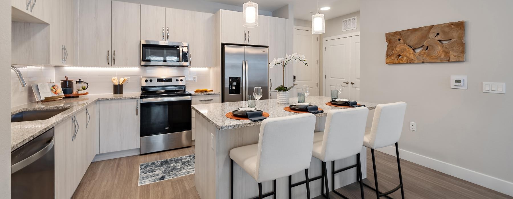 a kitchen and island with chairs