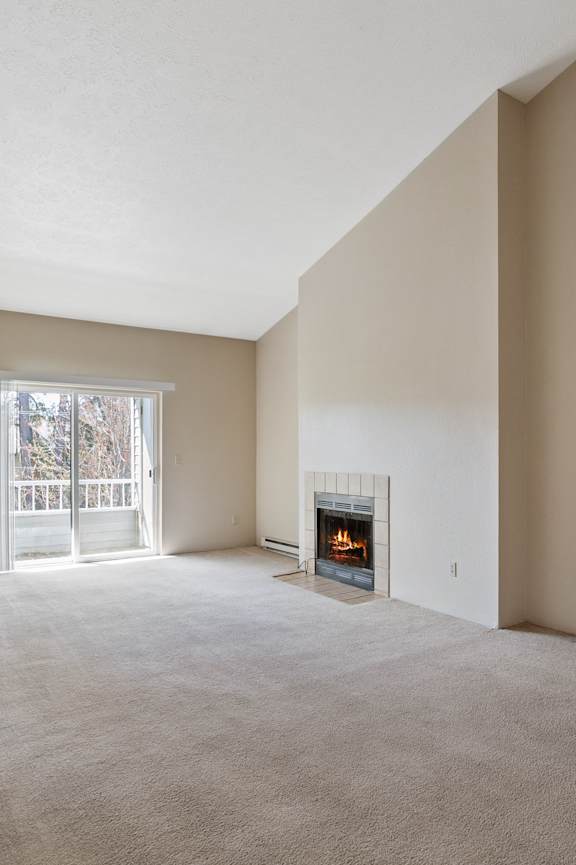 A living room with a fireplace and a sliding glass door.