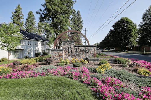 A garden with a sign that says "Brighton" in front of a house.
