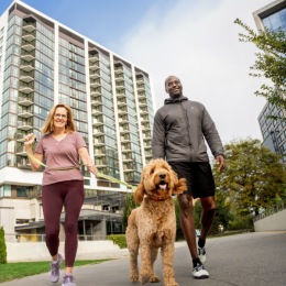 Two residents at Signal House walking a dog 