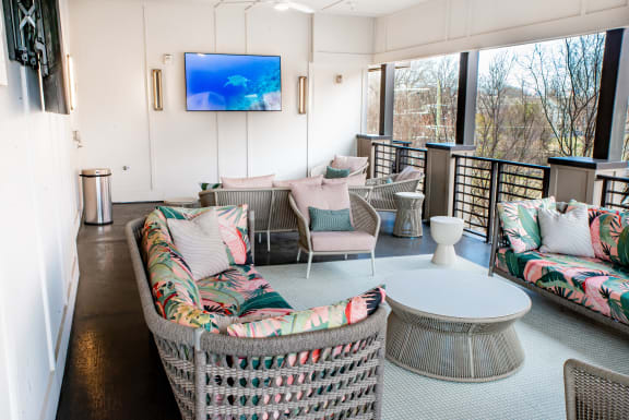 a rooftop lounge with wicker furniture and a television at Park and Kingston, Charlotte, 28203