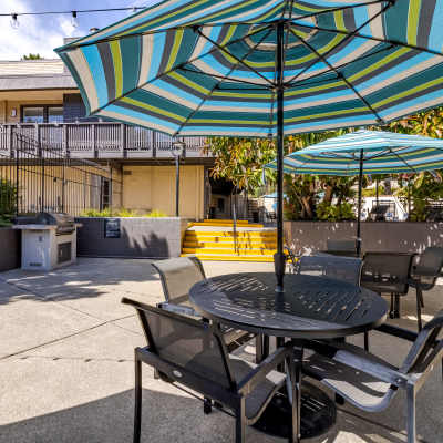 Outdoor patio with striped umbrella seating at The Ralston at Belmont Hills in Belmont, California