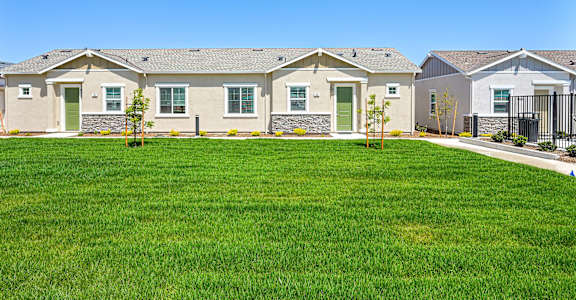 A row of houses with green lawns in front.