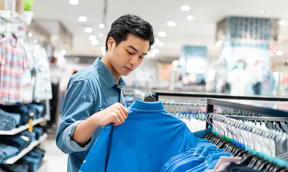man shopping for a shirt at a store
