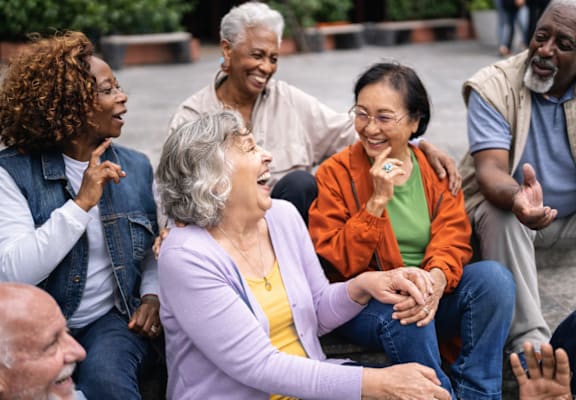 A group of people sitting together and laughing.