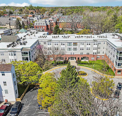 A large apartment complex with a parking lot in front.