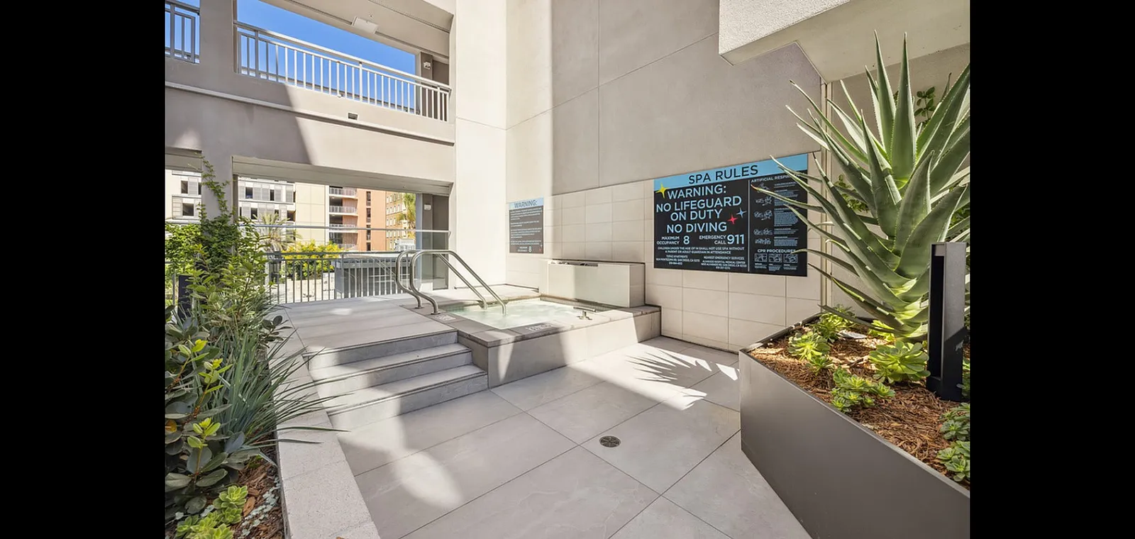 Inviting outdoor spa area with modern design, surrounded by lush greenery and ample sunlight.