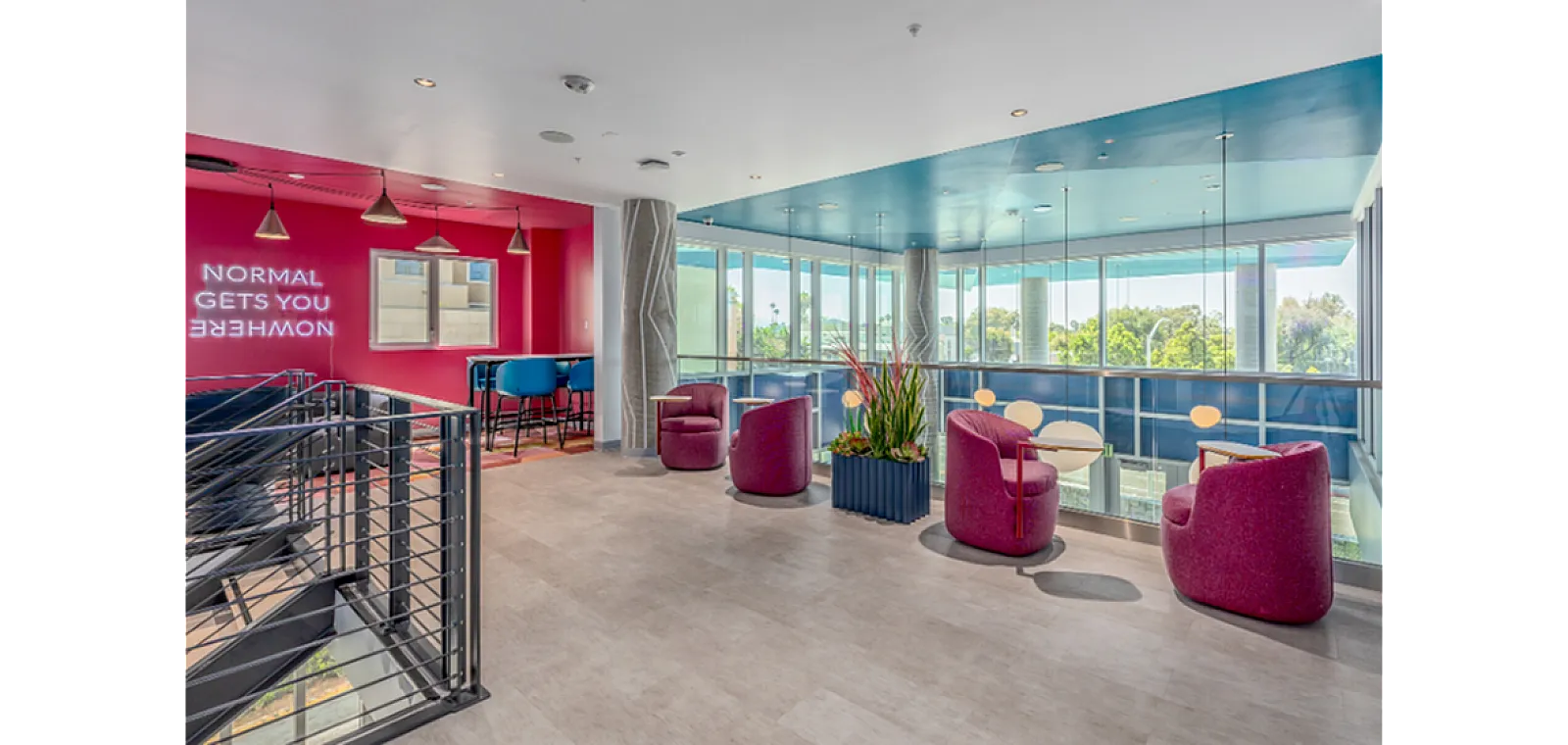 Vibrant community lounge with colorful seating, modern decor, and large windows offering scenic views.
