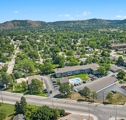 A bird's eye view of a residential area with a swimming pool and a road.