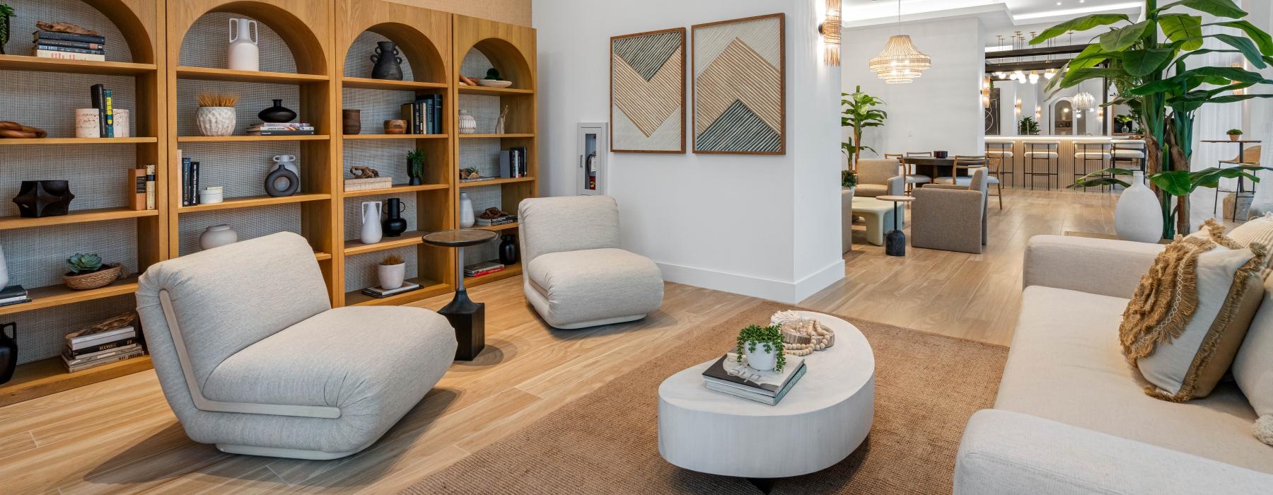 resident clubhouse seating area with couch, coffee table, cushioned chairs and bookshelves