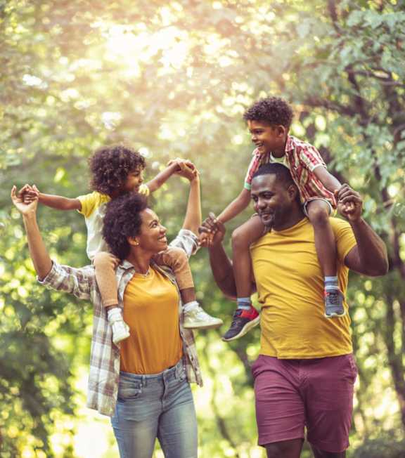 A family of four is playing in a forest.