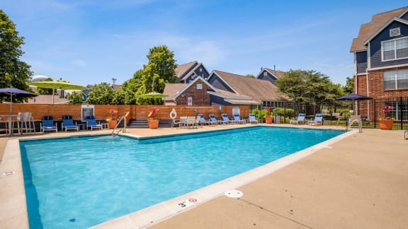 The Monroe Apartments in Glendale Heights, IL photo of a pool with lounge chairs and umbrellas