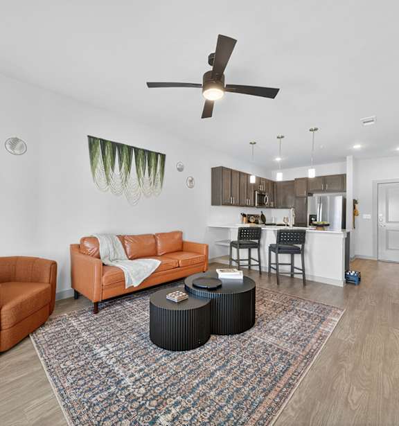 A living room with a brown sofa, orange armchair, and a black coffee table.