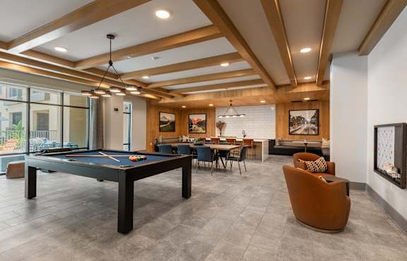 A room with a pool table and a couch.