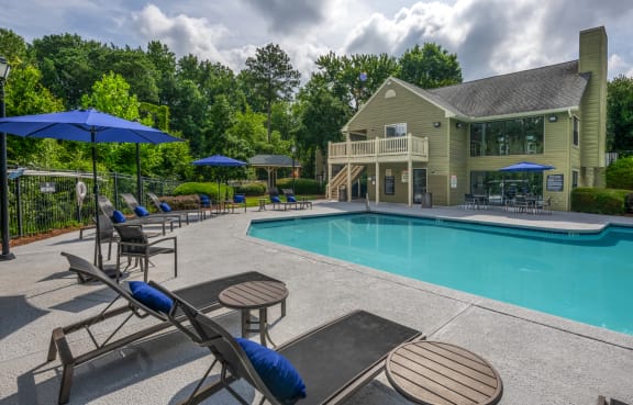 a backyard patio with a pool and a house